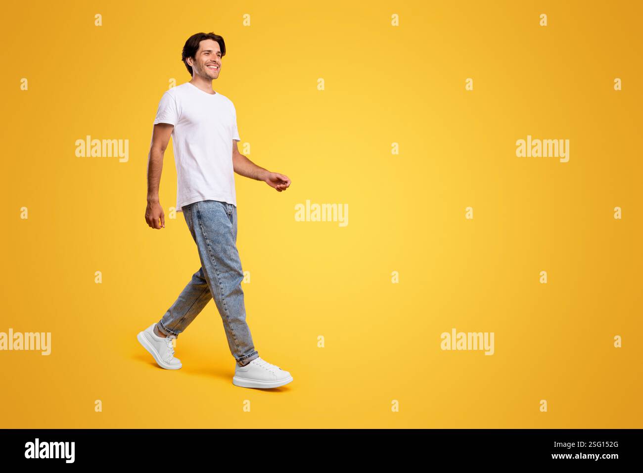Young bearded man walking isolated on yellow background Stock Photo