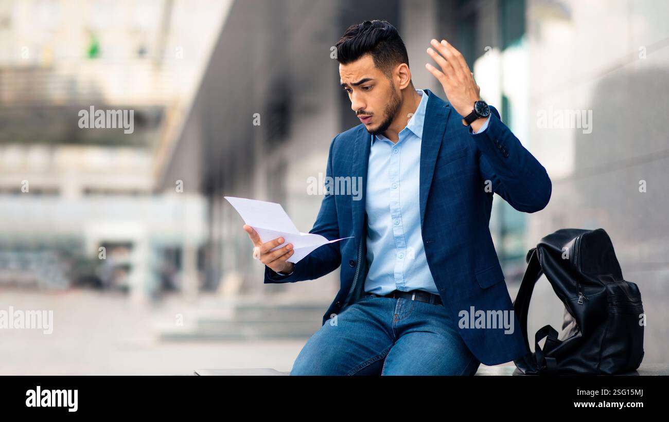 Emotional arabic guy young entrepreneur reading mail, copy space Stock Photo