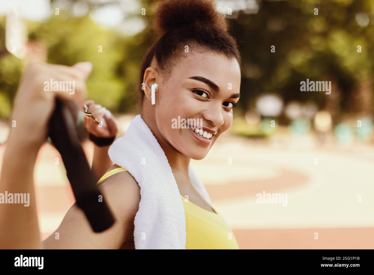 Smiling sporty black woman in yellow sportswear looking at camera Stock ...