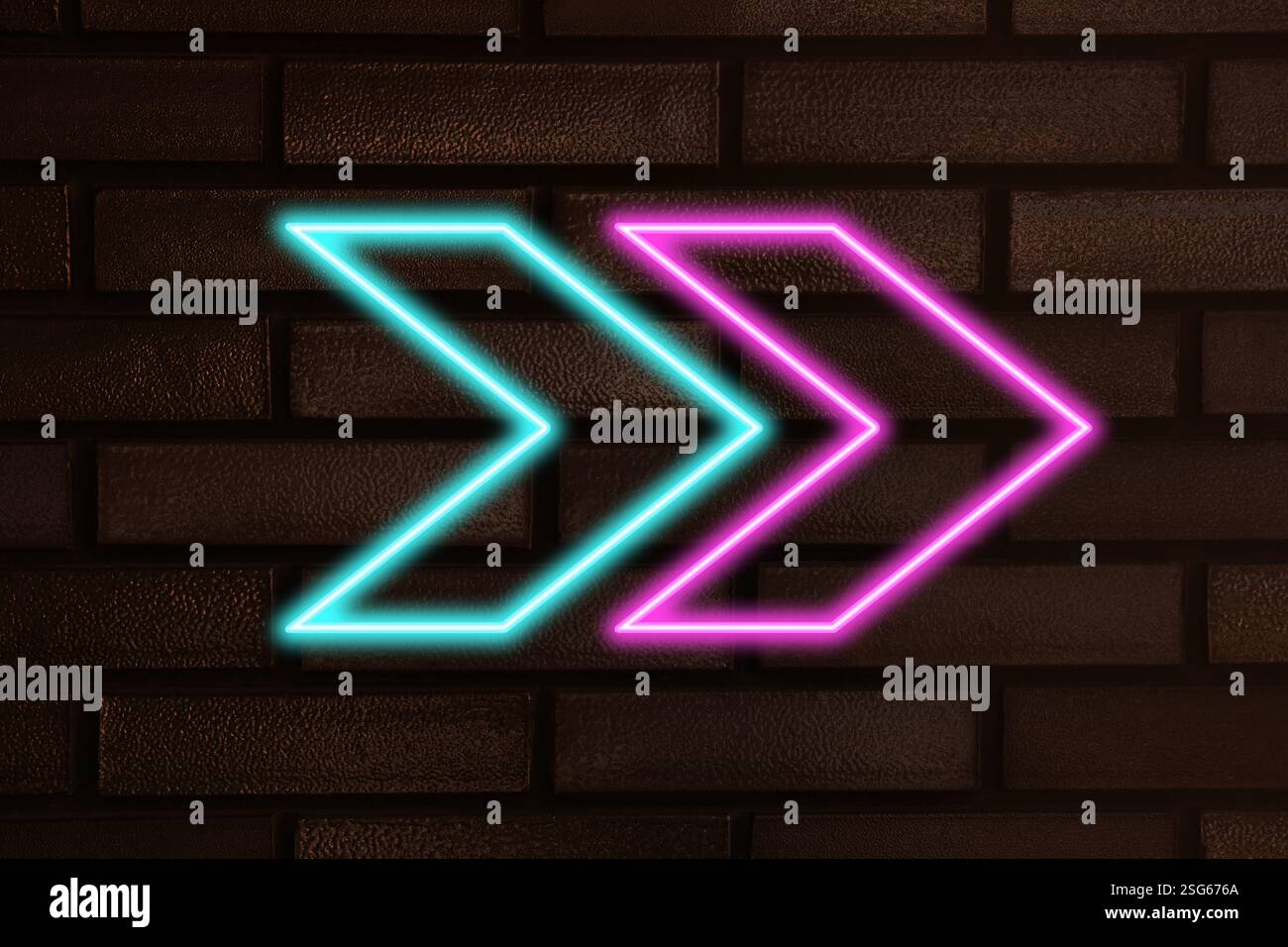 Bright neon arrow-shaped pointer on brick wall Stock Photo