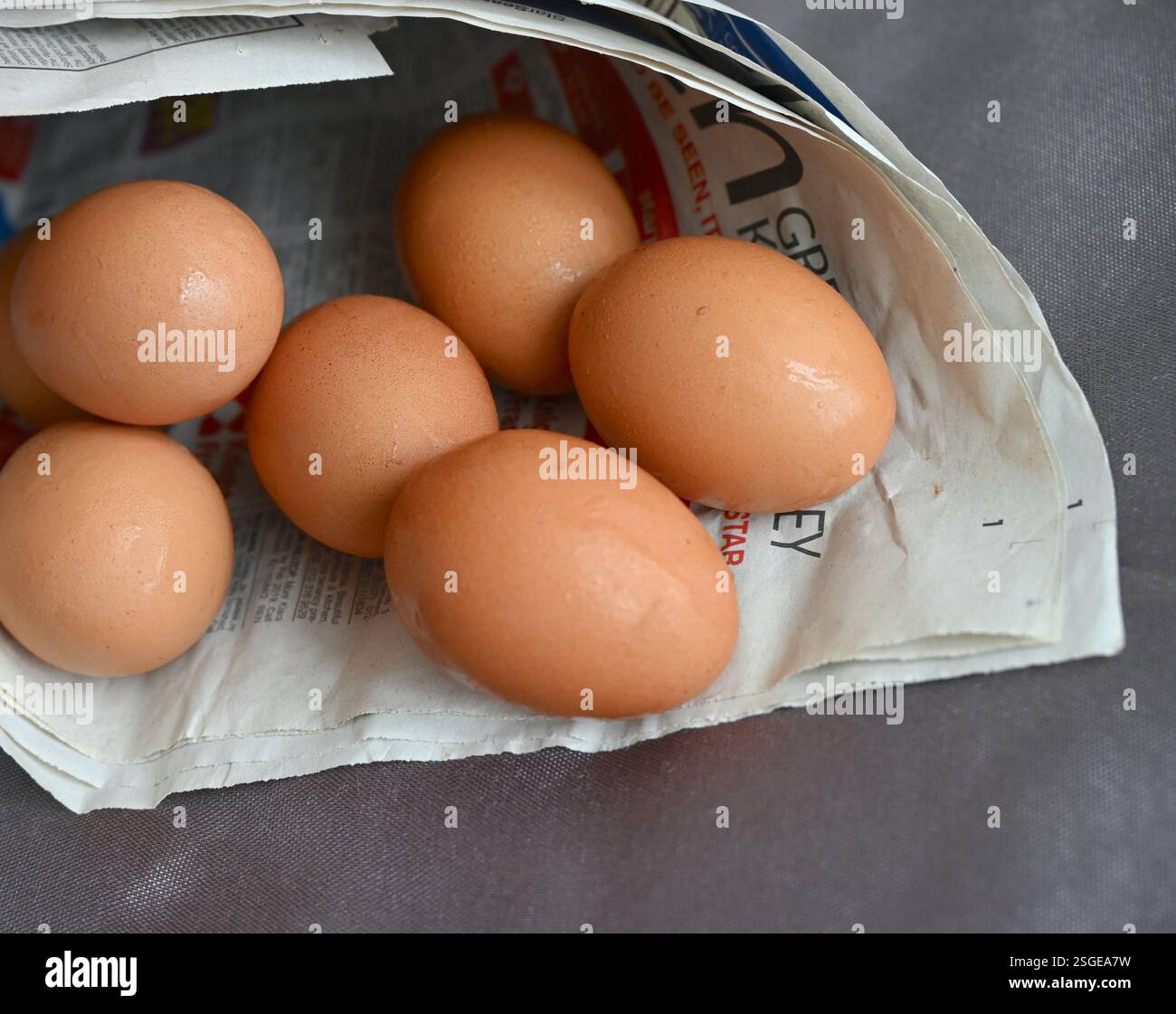 Brown natural eggs in newspaper cone. Stock Photo