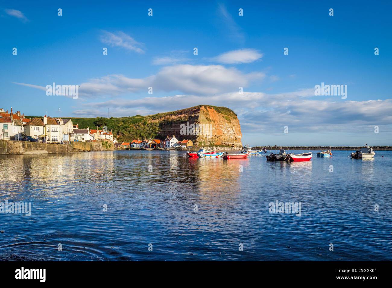 Early morning in summer at Staithes harbour on the North Yorkshire coast, overlooked by the headland of Cowbar Nab. Stock Photo