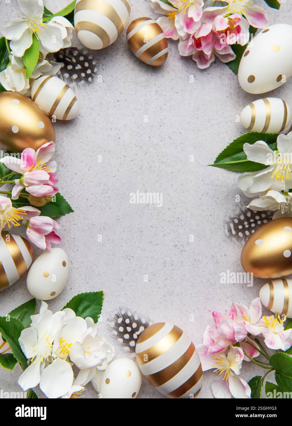 Golden eggs and flowers create a festive easter border on a light background Stock Photo