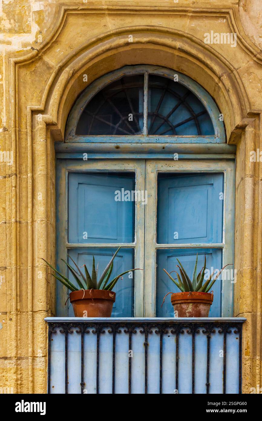 Rustic Stone Building Facade with Wooden Shuttered Windows and Plants ...