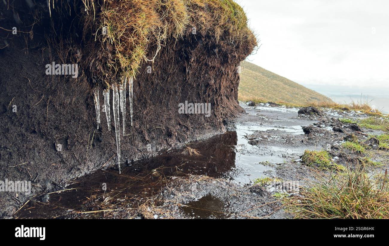 Frozen peat with icicles in the Scottish Highland mountains in winter with snow. Rolling hills in the outdoors in Scotland. Wild nature view across be - Smartphone Captured Stock Image