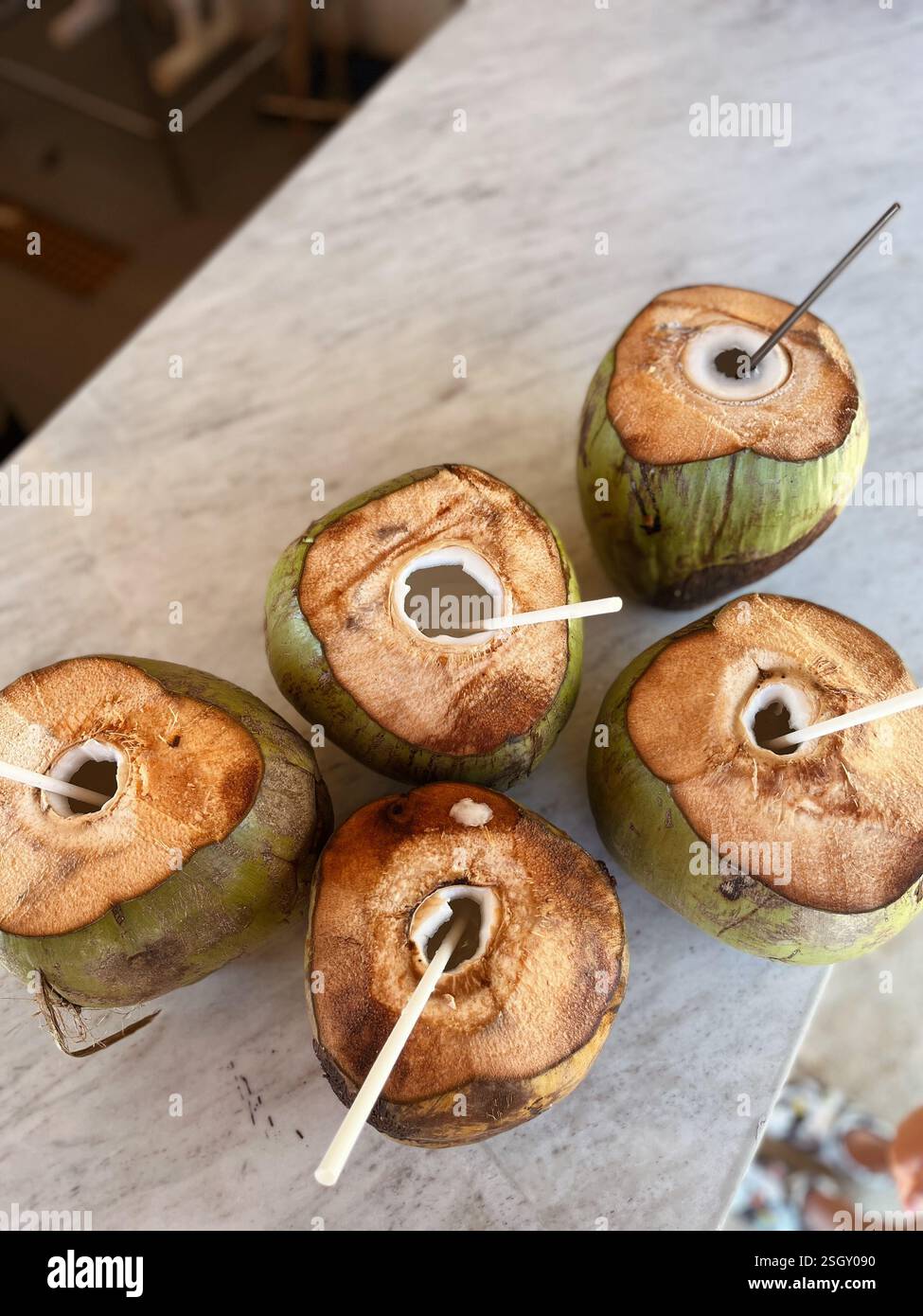 Coconuts with Straws on a Counter - Smartphone Captured Stock Image