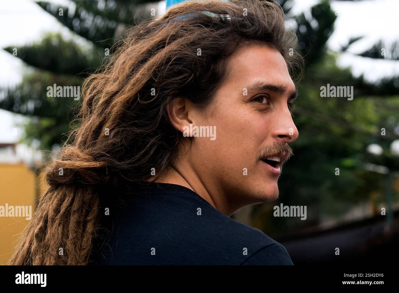 Surfer with Long Hair Standing in the Streets of Lima – Close-Up Portrait Stock Photo