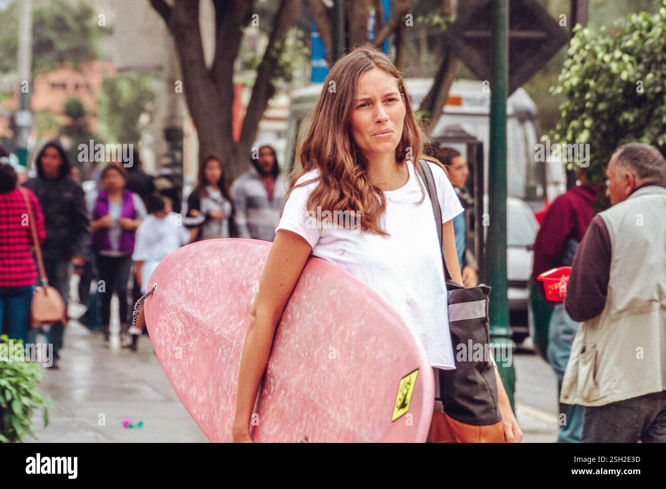 Woman Carrying a Surfboard Walking Through Barranco Streets – Lima Stock Photo