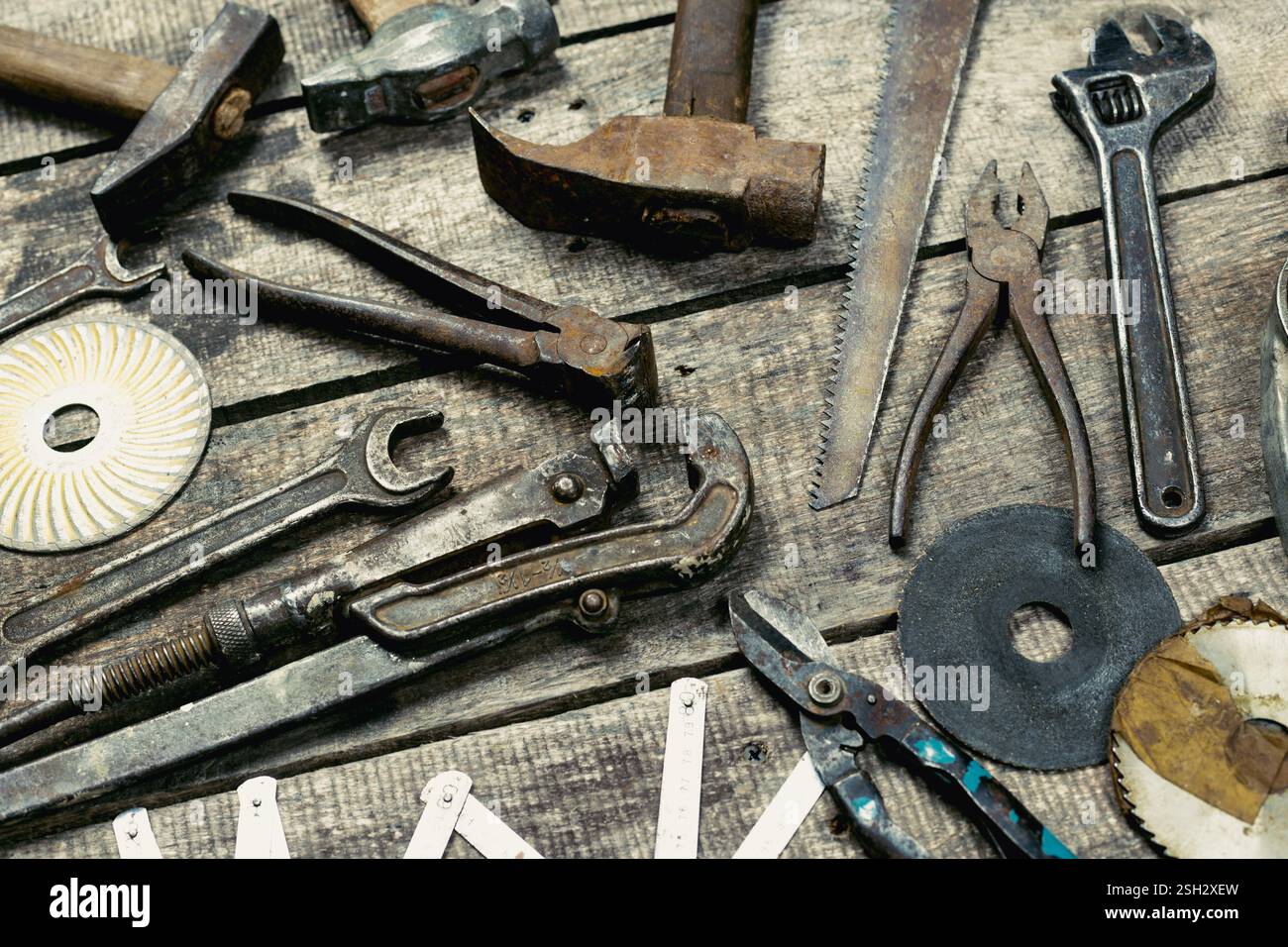 Assorted hand tools displayed on rustic wooden surface in workshop setting during daylight hours Stock Photo