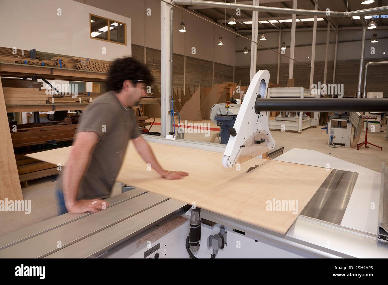 Man Operating a Table Saw for Woodwork in Carpentry Workshop Stock Photo