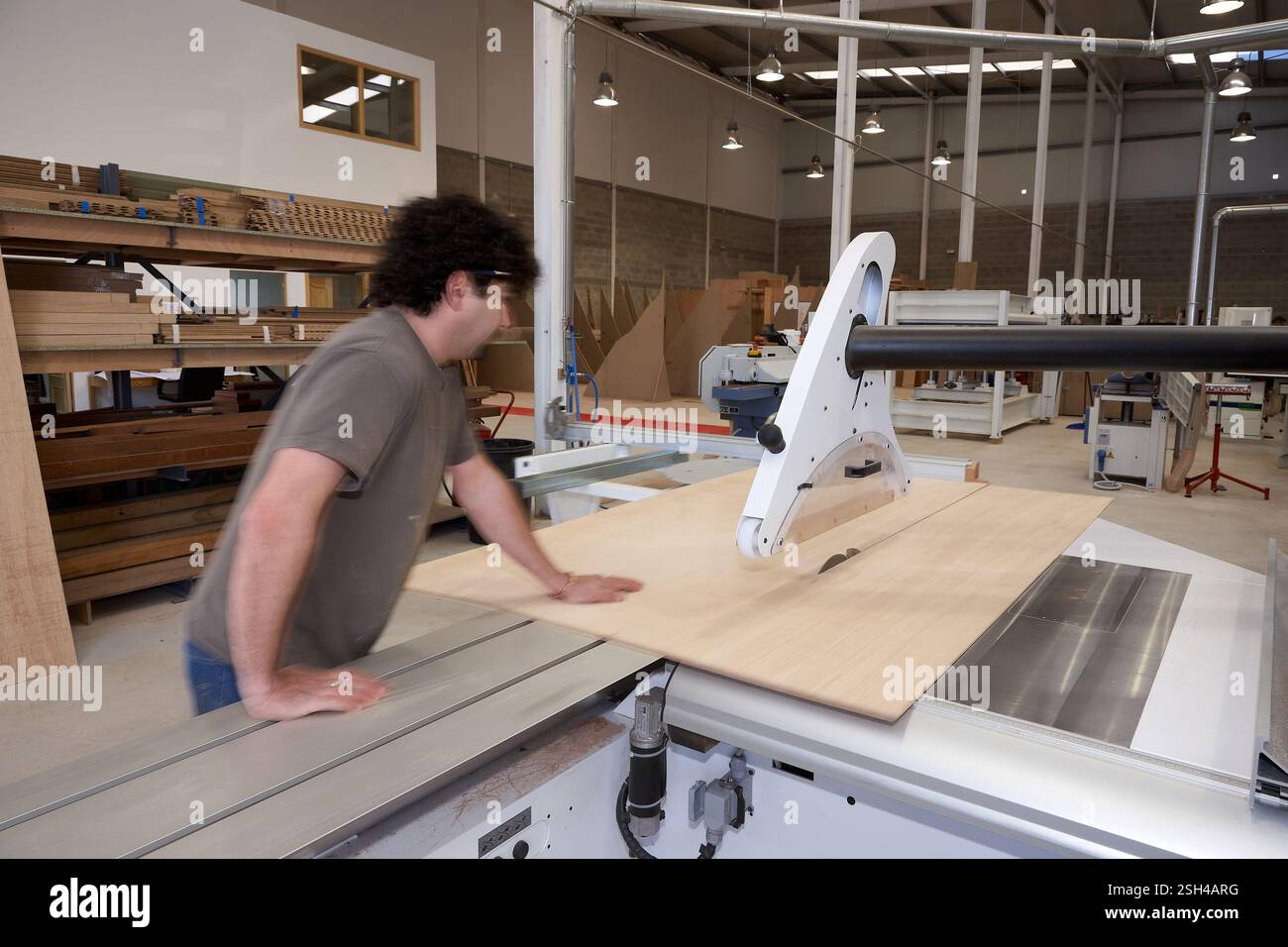 Man Operating a Table Saw for Woodwork in Carpentry Workshop Stock Photo