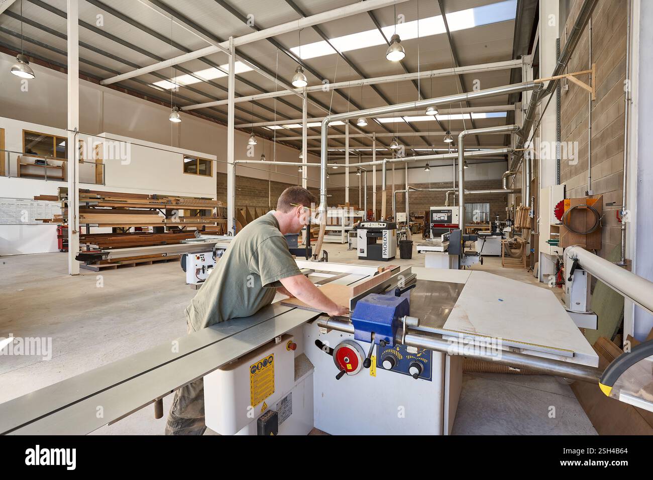 Man Operating a Table Saw for Woodwork in Carpentry Workshop Stock Photo