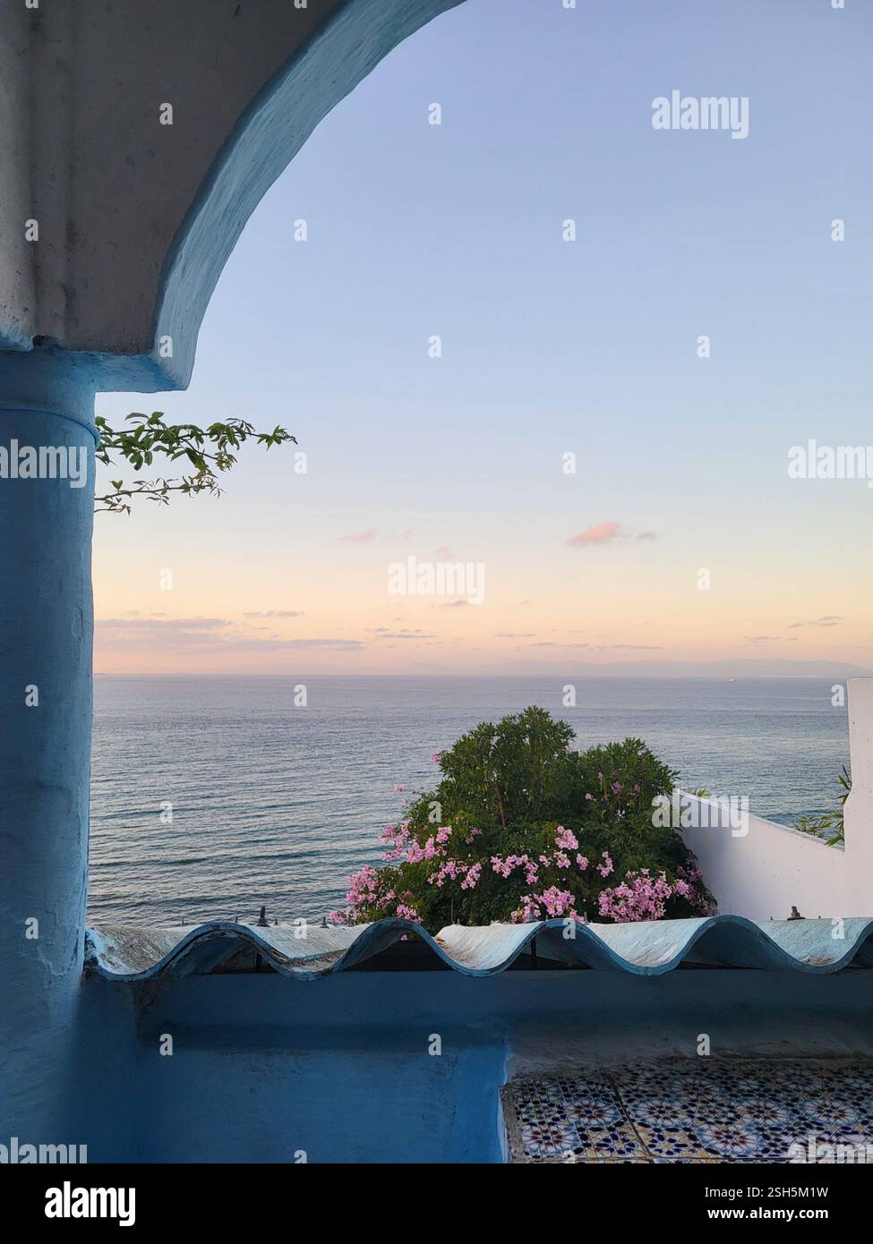 Beautiful sunset view from Café Hafa in Tanger, Morocco, overlooking the sea with traditional blue architecture and a peaceful ambiance. - Smartphone Captured Stock Image