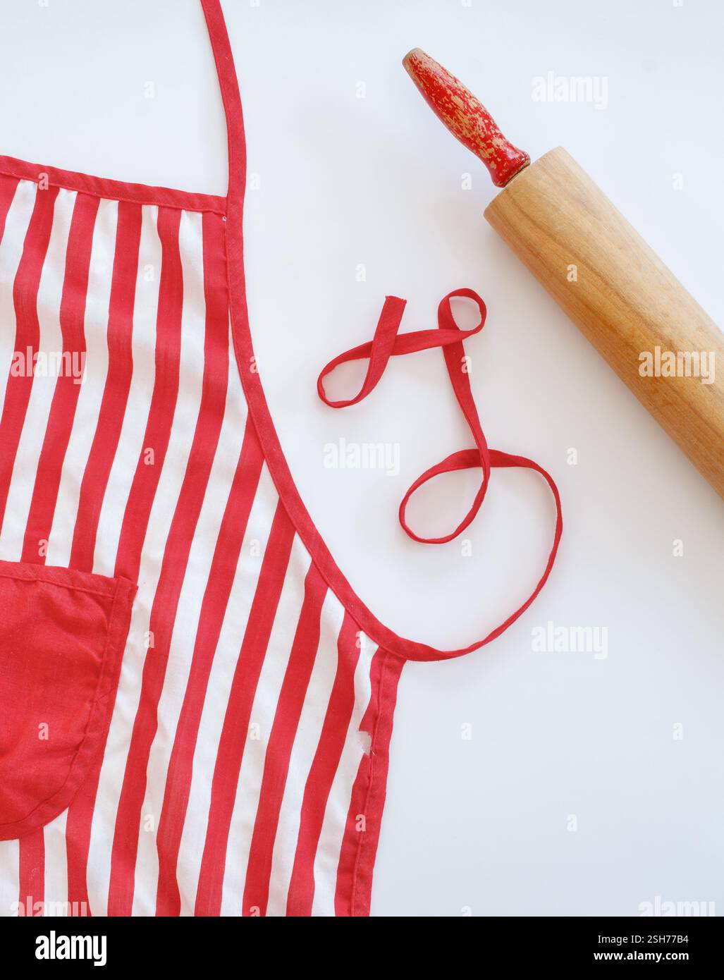 Red and white kitchen apron with rolling pin Stock Photo - Alamy