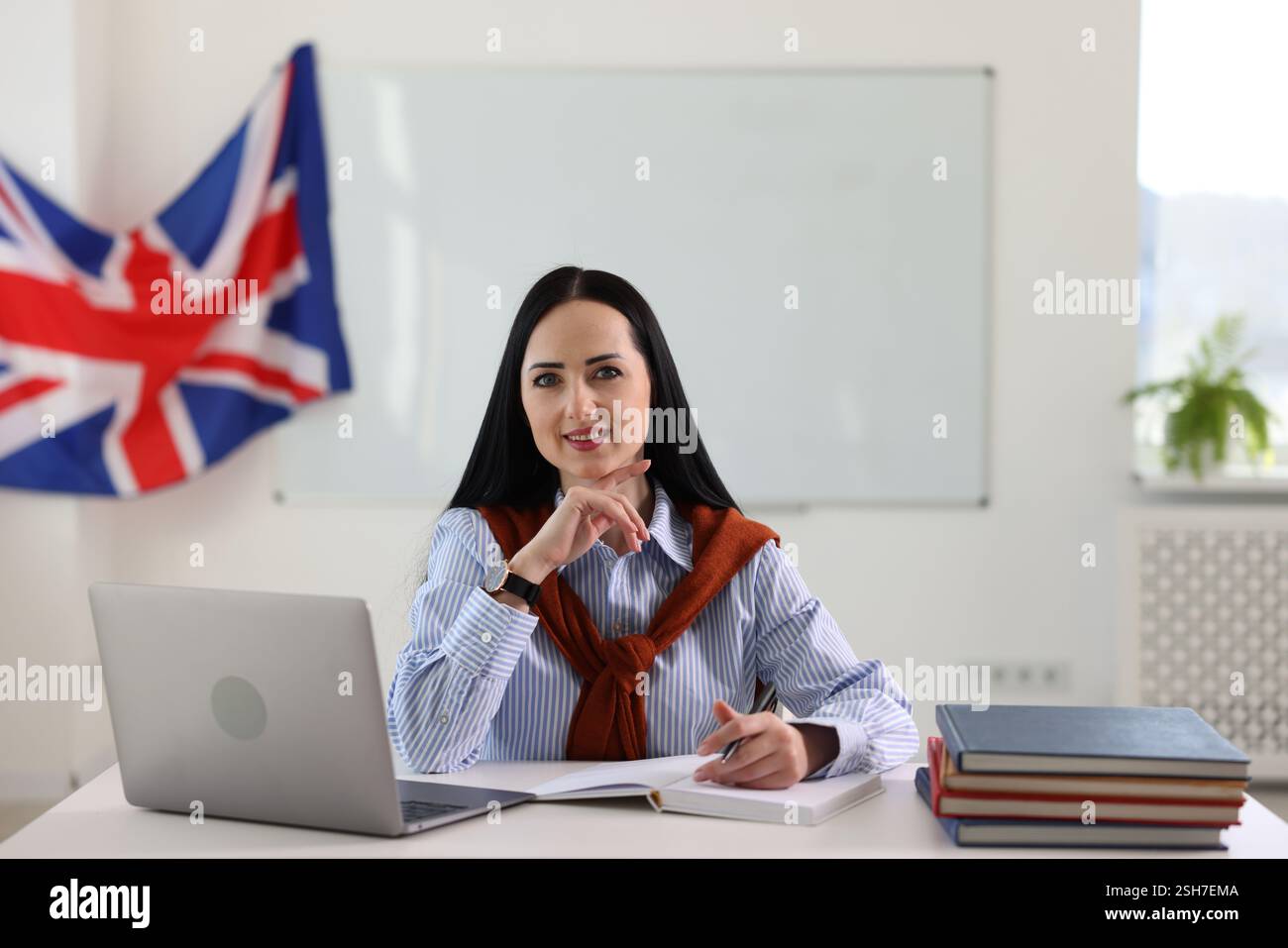 English teacher working at desk in classroom Stock Photo - Alamy