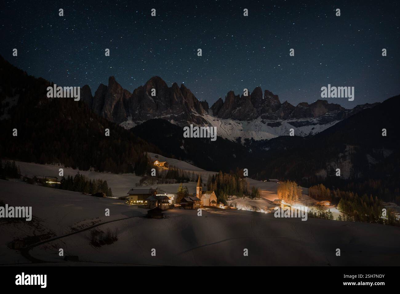 Santa Magdalena Village at Night with Odle Dolomites in backgrounf and stunning starry sky above them Stock Photo