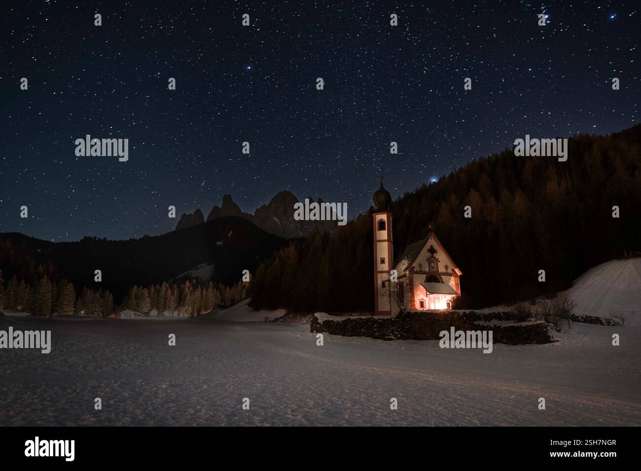Ranui Chapel at Night with Odle Dolomites in backgrounf and stunning starry sky above them Stock Photo