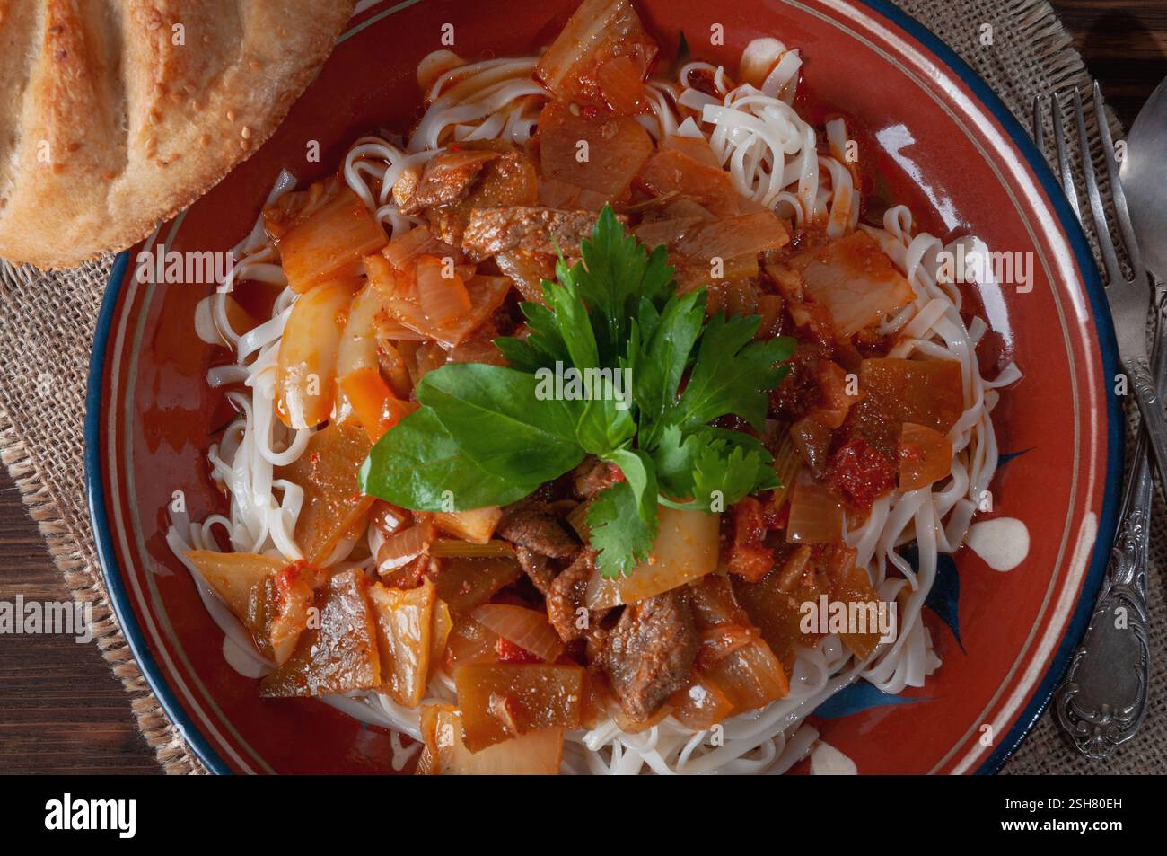 Hot Uighur dish served with herbs and flatbread Stock Photo