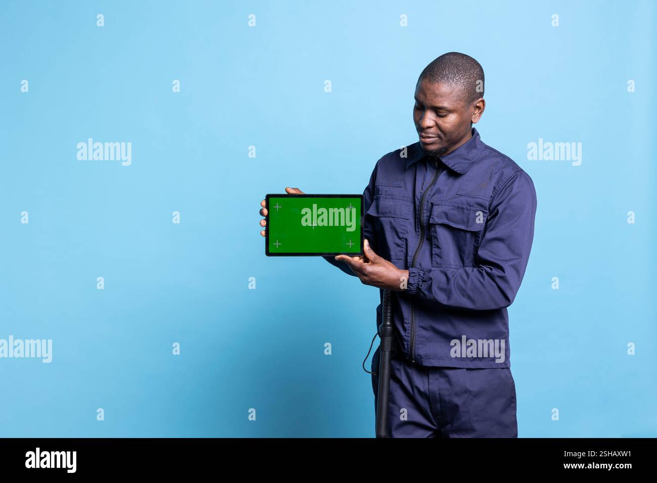 Security guard showing a tablet with mockup display against blue ...