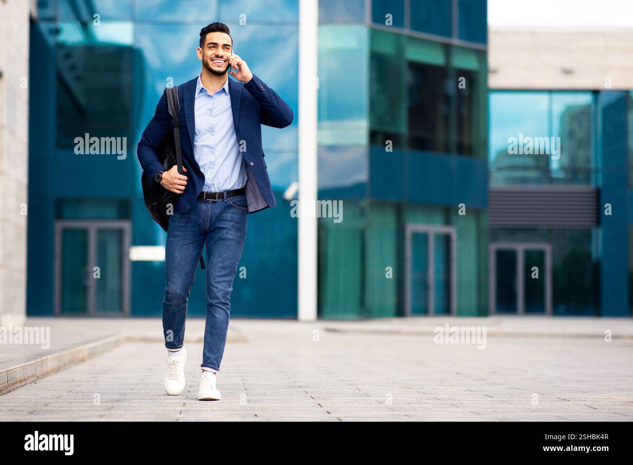 Young middle-eastern entrepreneur going home, talking on phone Stock Photo