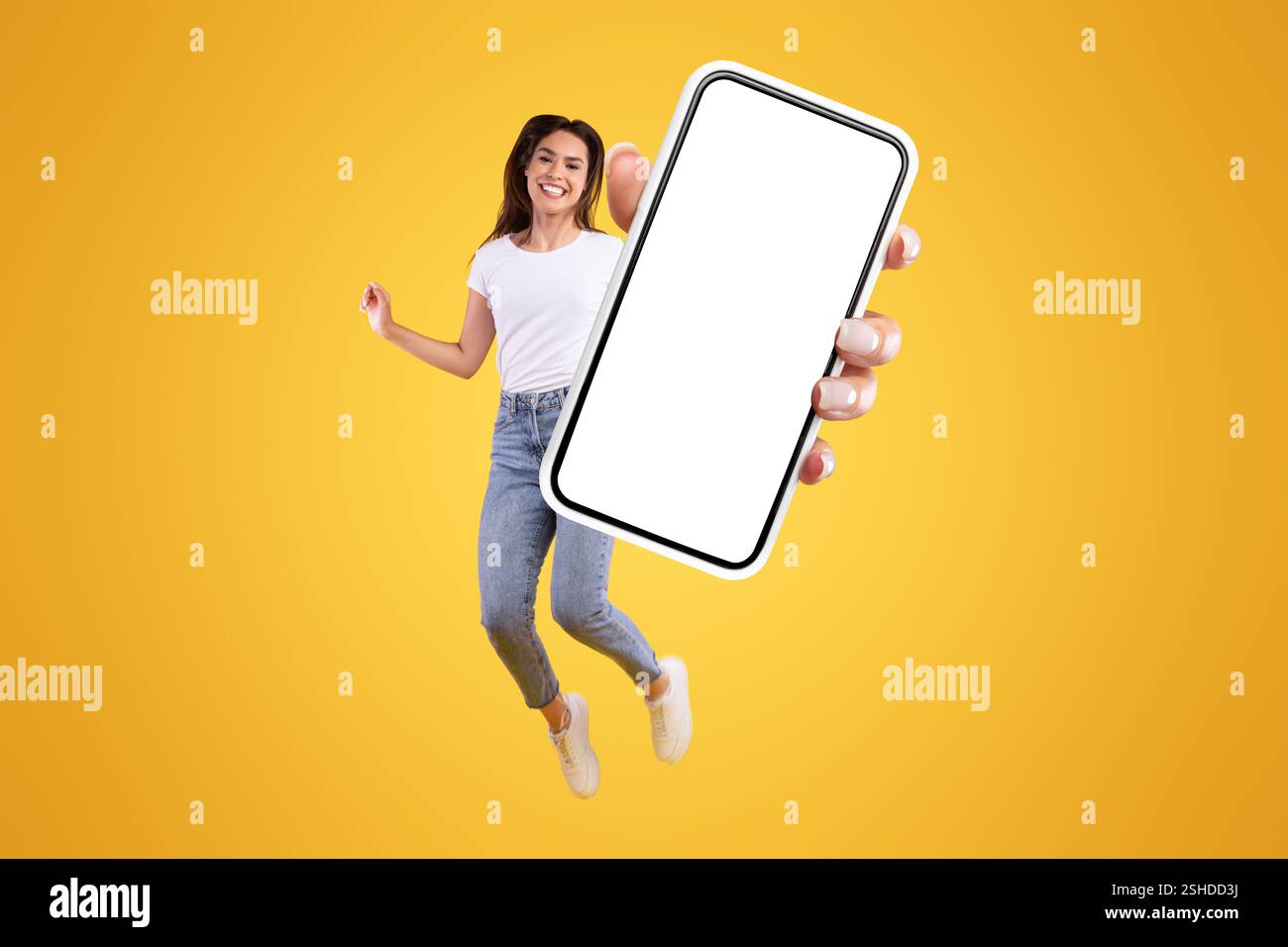 Woman showing white empty smartphone screen and jumping up high Stock ...
