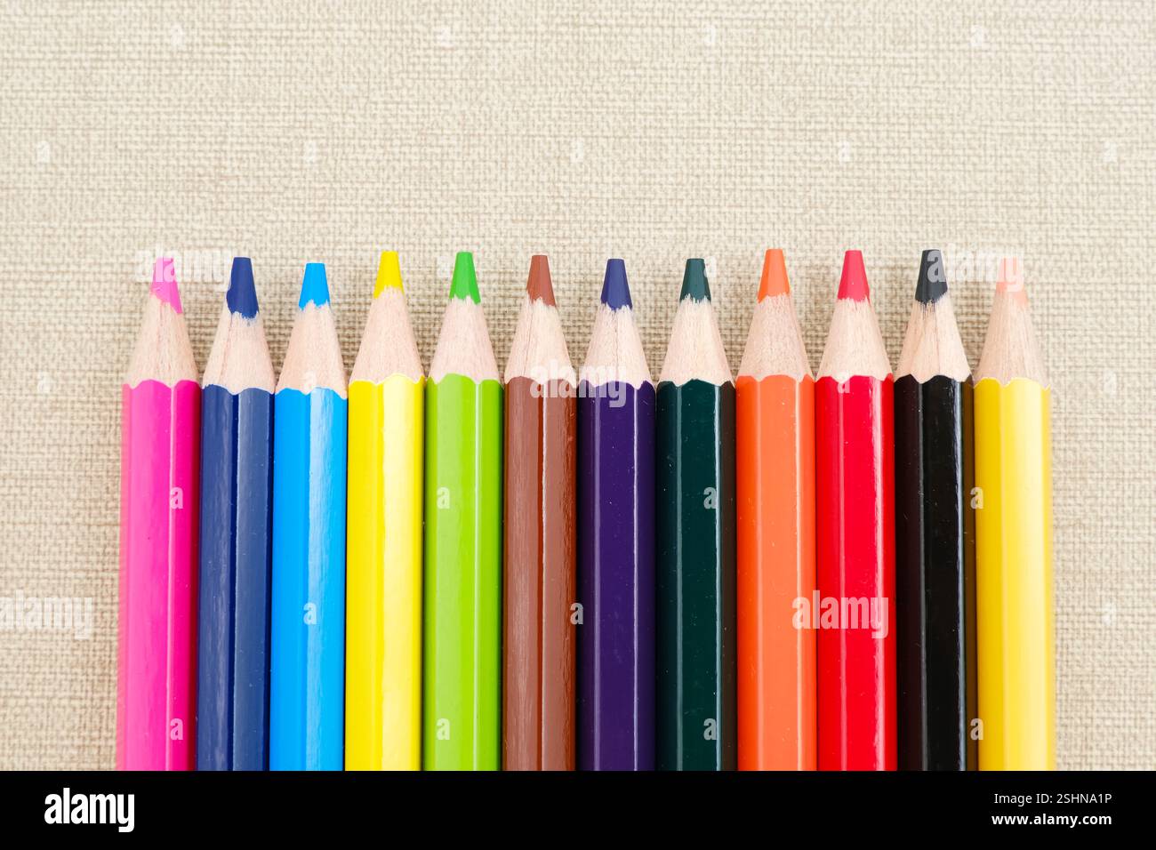 Colorful sharpened pencils are lined up on the table. Flat lay Stock Photo