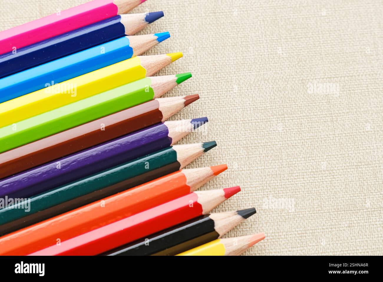 Colorful sharpened pencils are lined up on the table. Flat lay Stock Photo
