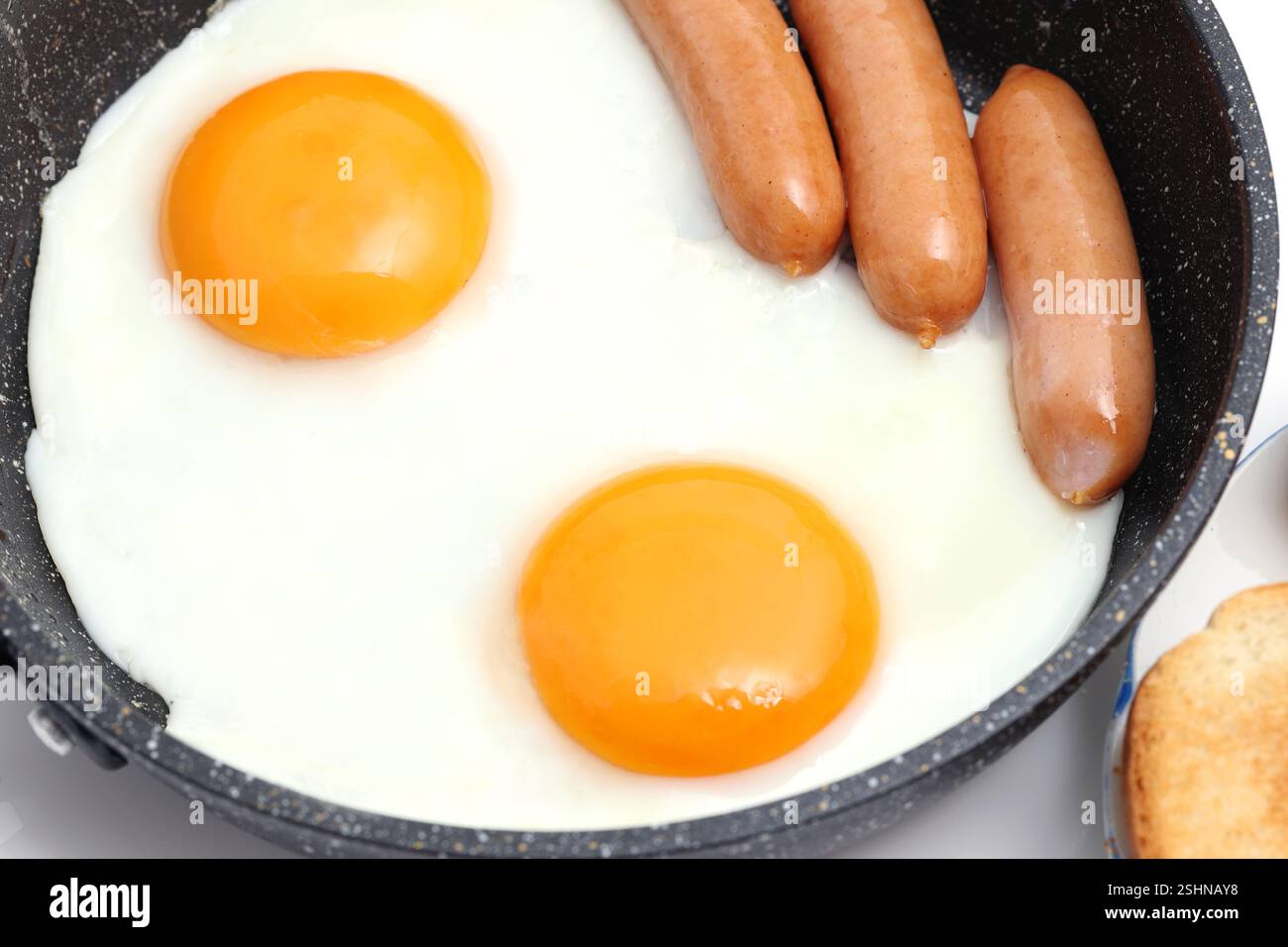 close up of fried egg with sausage fried in a frying pan Stock Photo ...