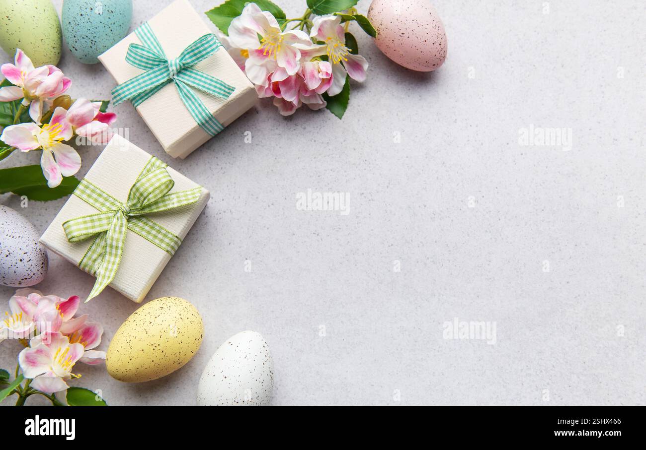 Pastel eggs and gift boxes with flowers on a light background Stock Photo