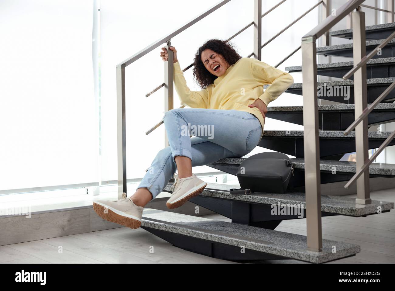 Injured woman on stairs in building after fall. Dangerous accident ...