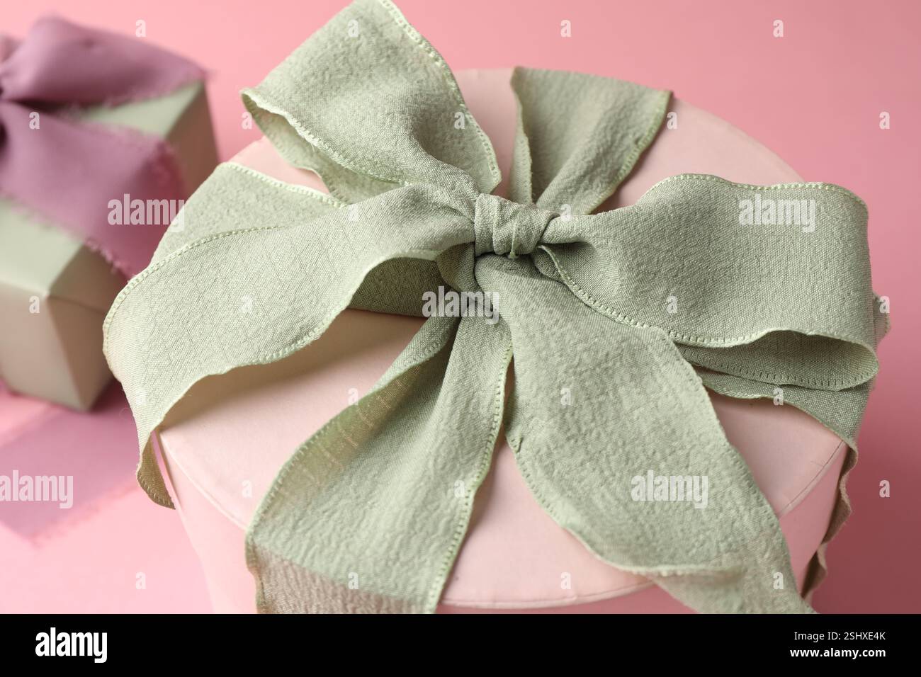 Different gift boxes with bows on pink background, closeup Stock Photo
