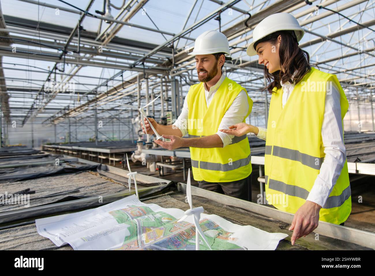 Two engineers working on the construction plan and looking involved Stock Photo