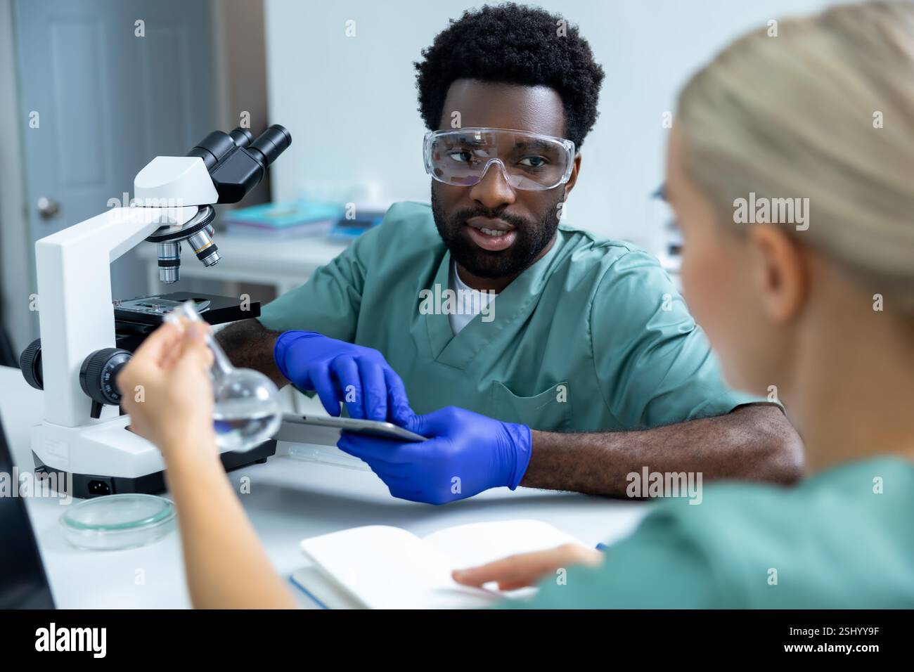 Woman and man doctors studying biochemistry using advanced technology in laboratory Stock Photo