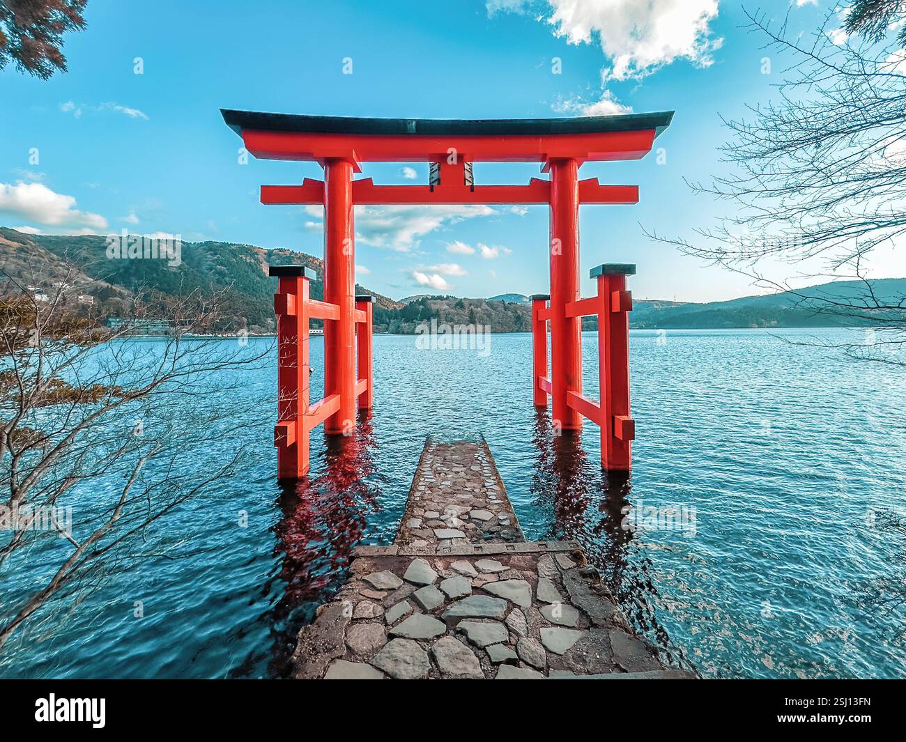 Torii of Hakone Shrine at Lake Ashi in the Hakone area of Kanagawa Prefecture in Honshū, Japan. Traditional red Japanese gate in the crater lake. - Smartphone Captured Stock Image