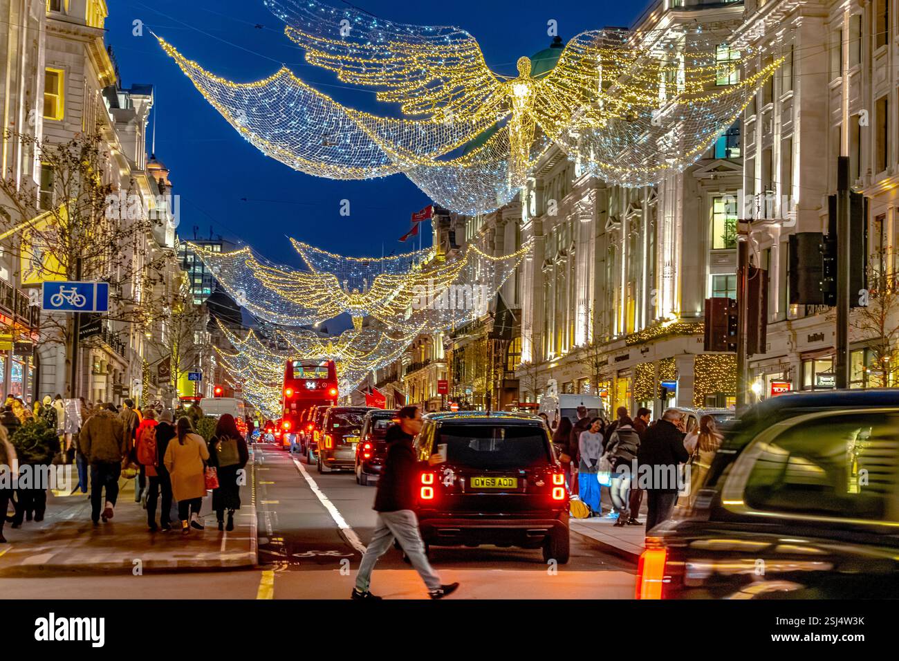 Crowds of people on Regent Street under the Christmas lights  at Christmas time , London W1 ,UK Stock Photo