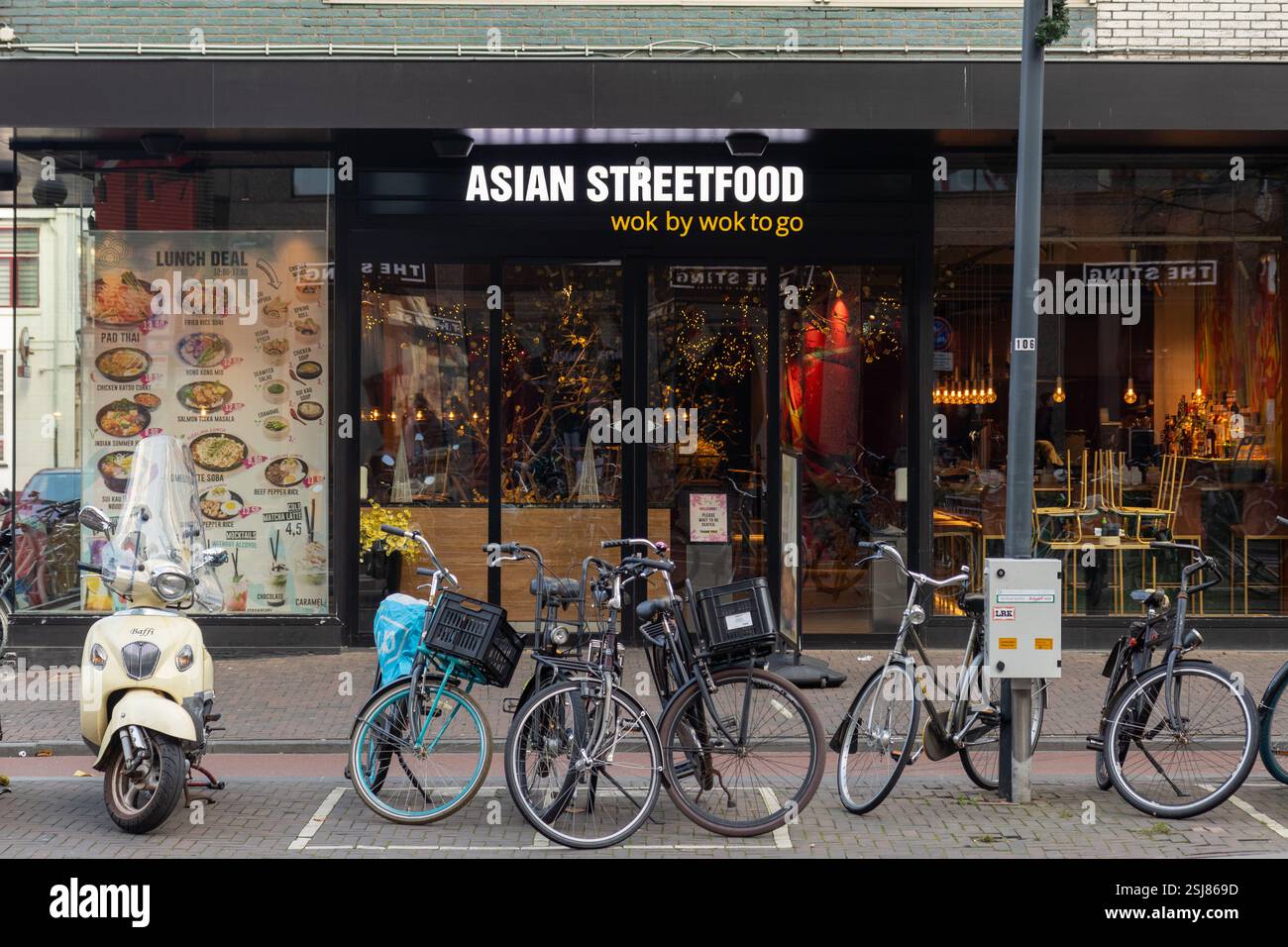 Asian Streetfood wok to go is a restaurant for Asian food, bikes in front of the restaurant Stock Photo