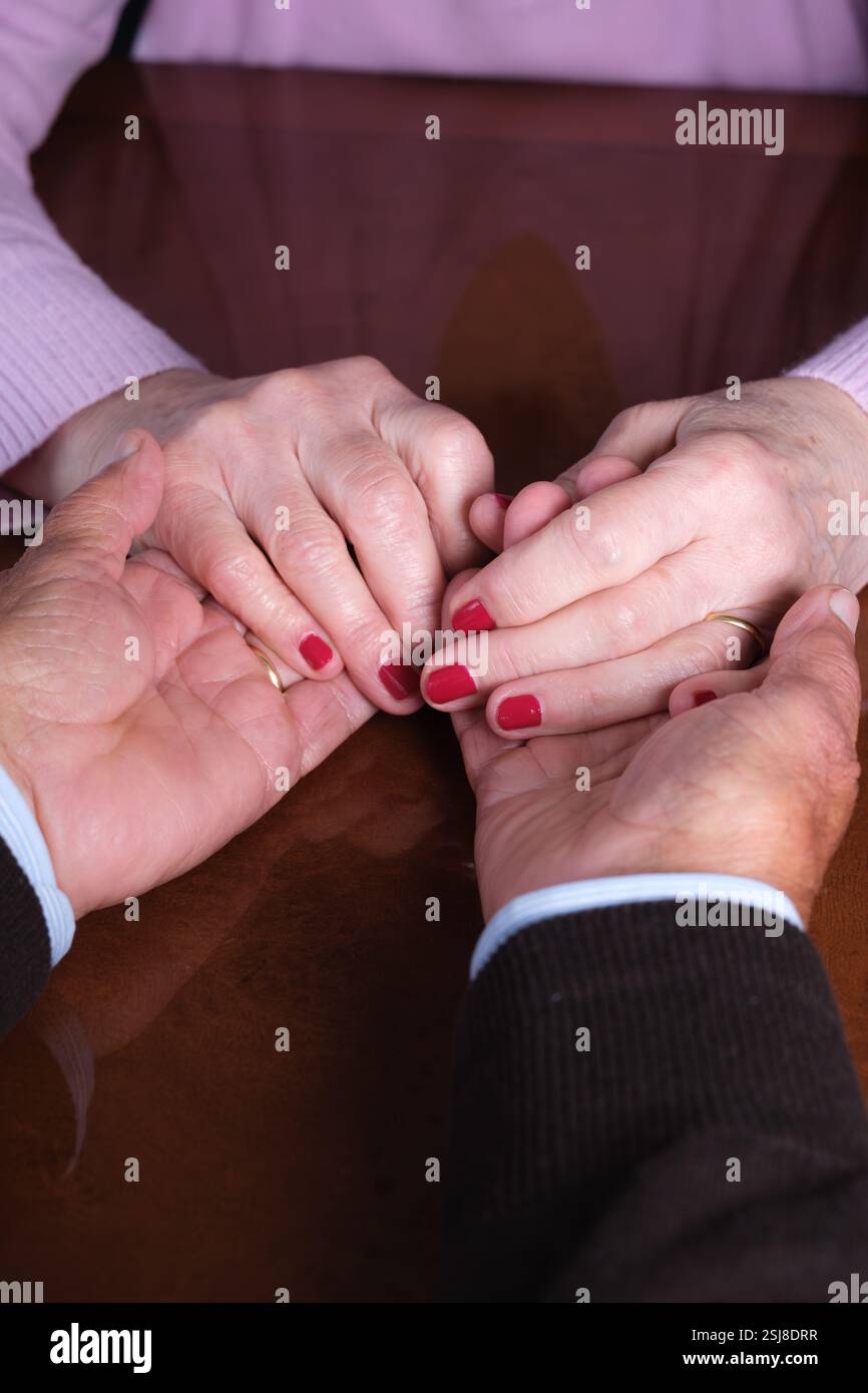 Elderly couple holding hands with love and affection Stock Photo