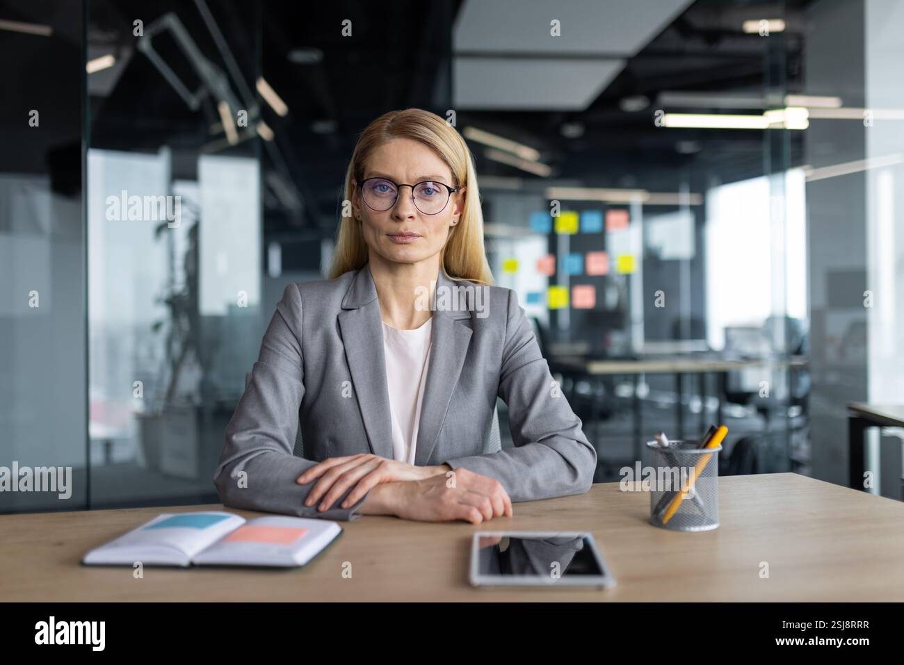 Successful confident female boss at workplace looking at camera, serious and concentrated. Businesswoman inside office at workplace. Stock Photo
