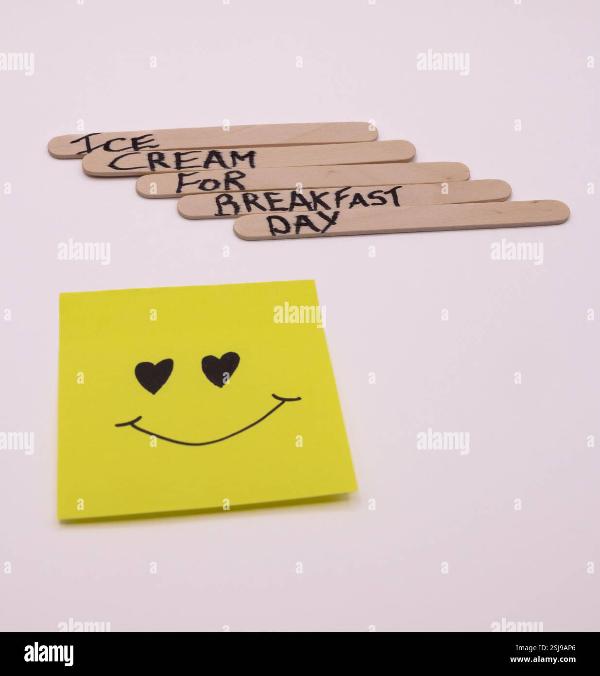 A concept of handwritten popsicle sticks with a heart emoticon on a ...