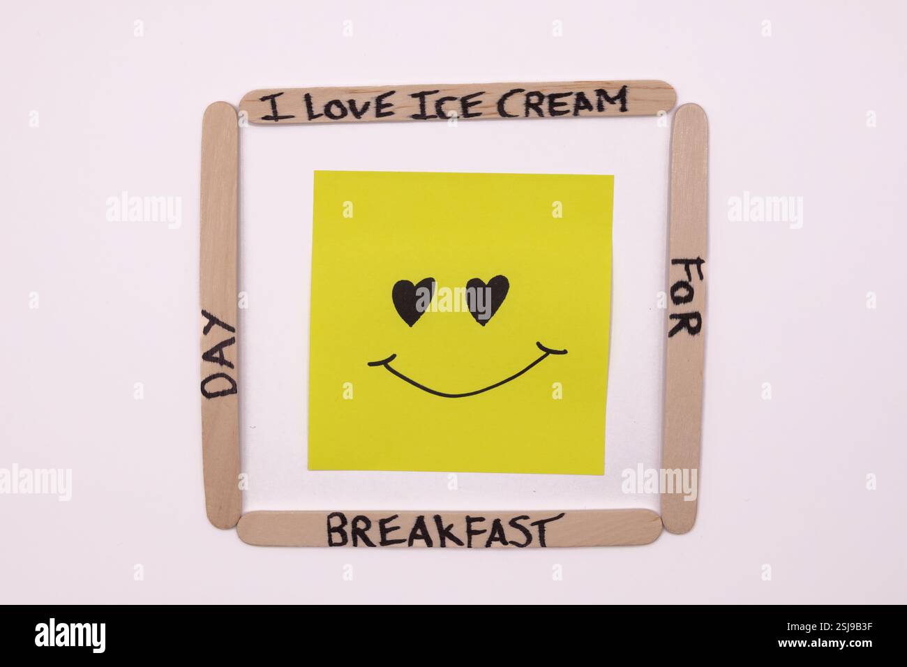 A concept of handwritten popsicle sticks with a heart emoticon on a ...