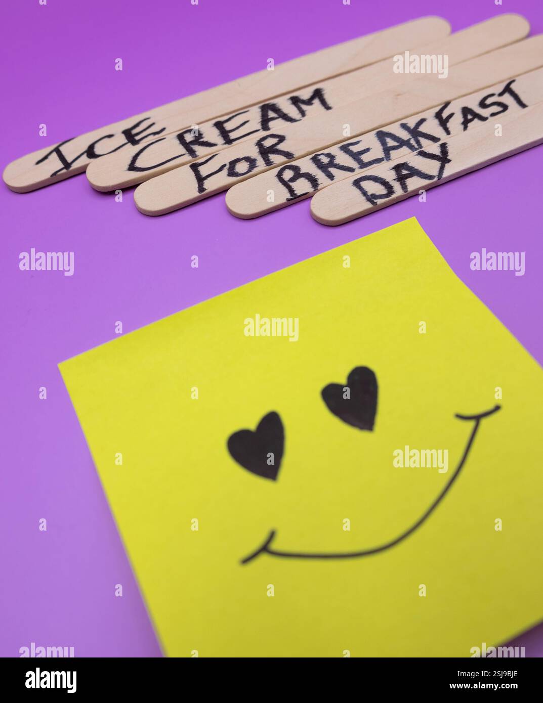 A concept of handwritten popsicle sticks on a purple background and a ...