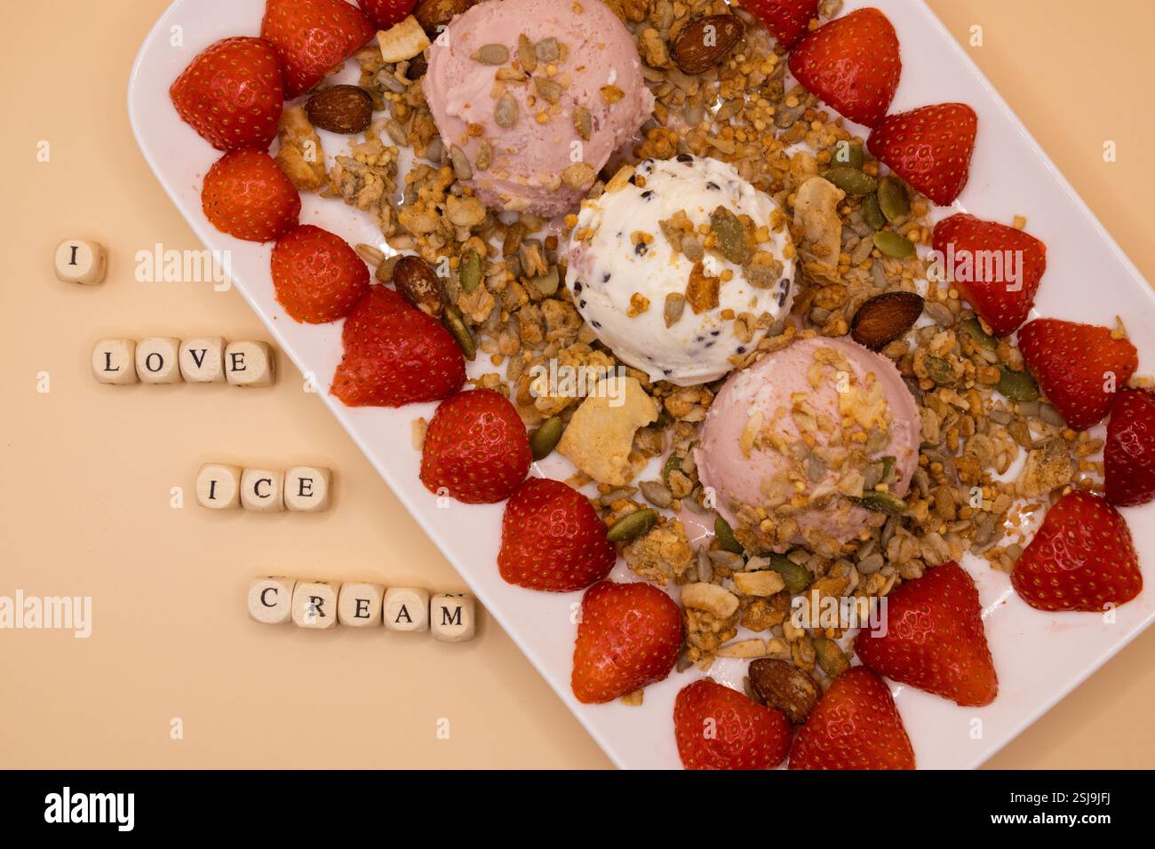 A plate of ice cream scoops with strawberries and granola for ice cream for breakfast day Stock Photo