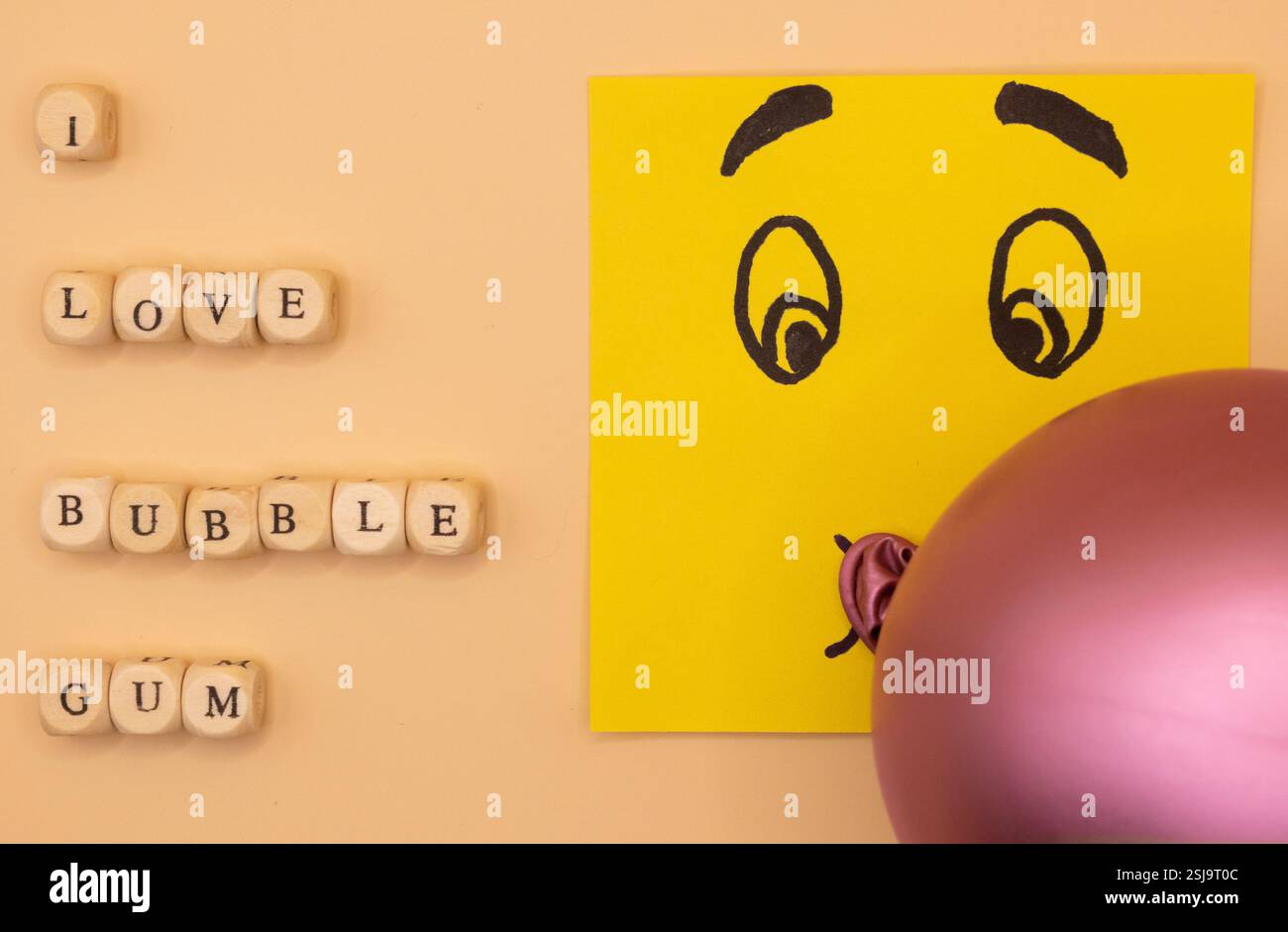 A concept of an emoticon notepad, blowing a bubble of bubble gum on a ...
