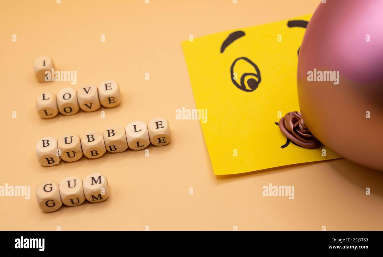 A concept of an emoticon notepad, blowing a bubble of bubble gum on a ...