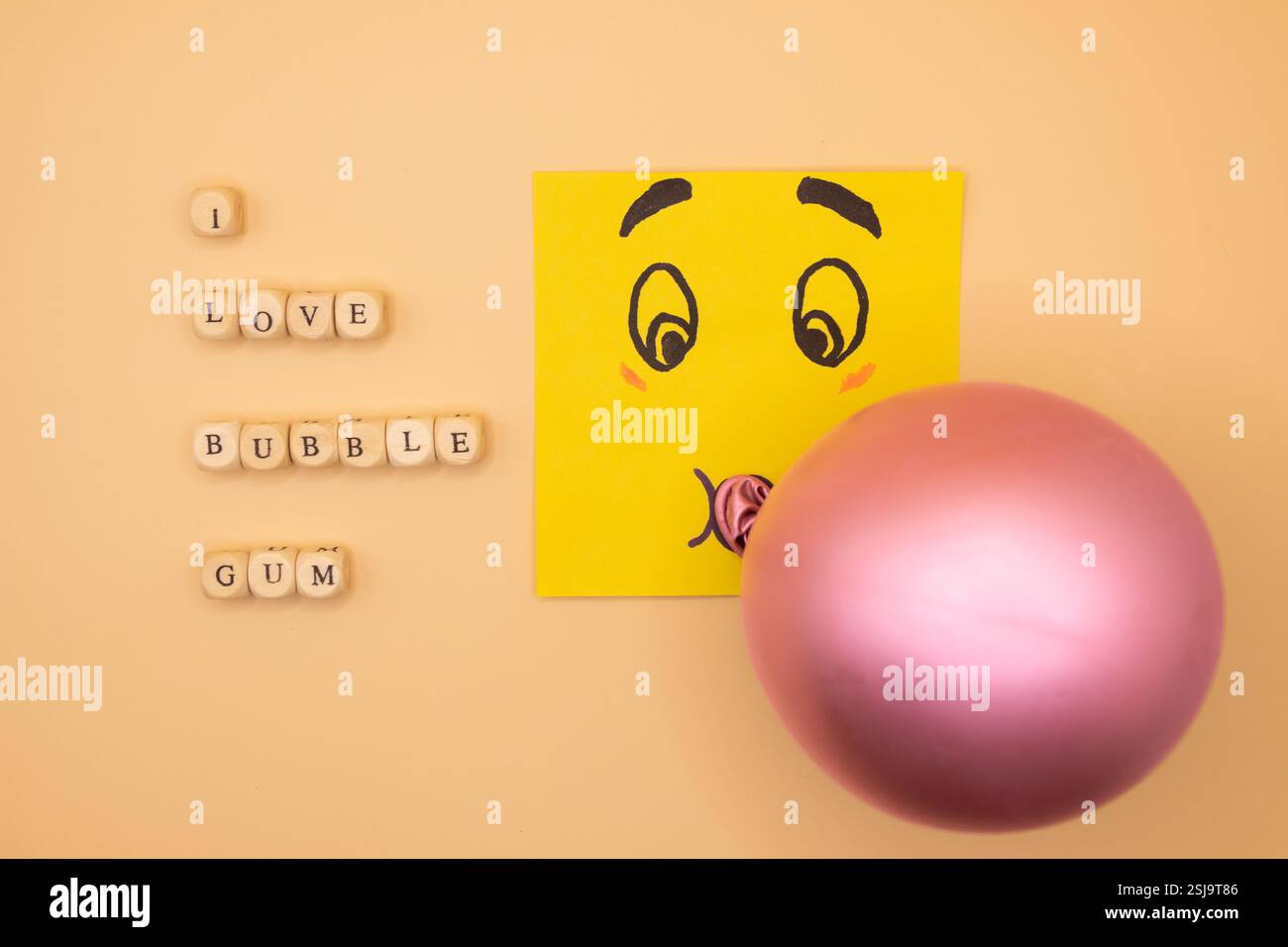 A concept of an emoticon notepad, blowing a bubble of bubble gum on a ...