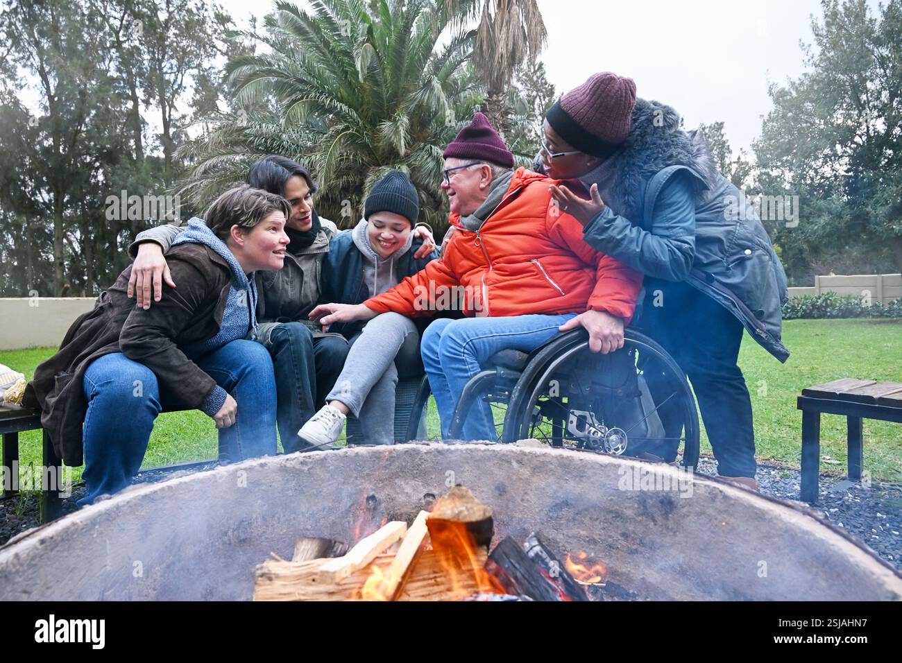 Friends by fire pit in garden Stock Photo
