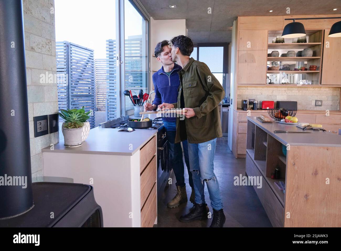 Gay couple kissing in kitchen Stock Photo