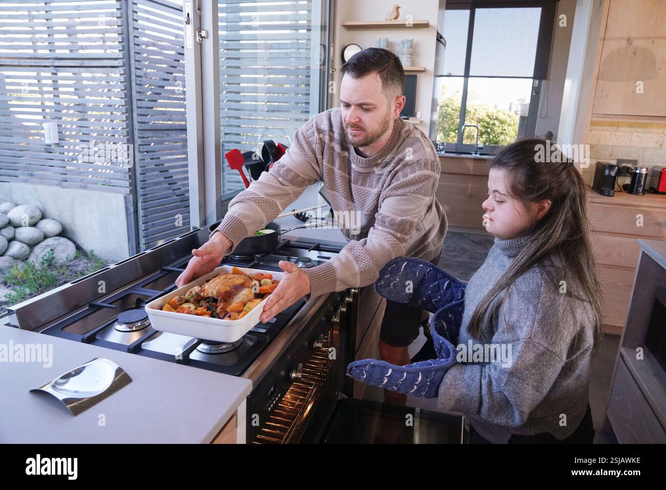 Disabled man and woman preparing dinner in kitchen Stock Photo