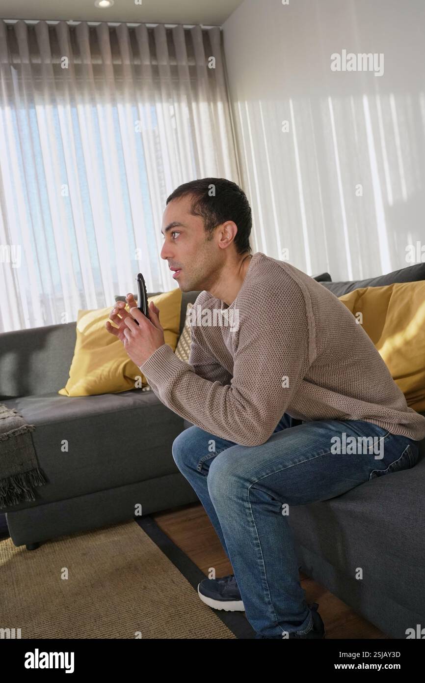 Man watching TV in living room Stock Photo Alamy