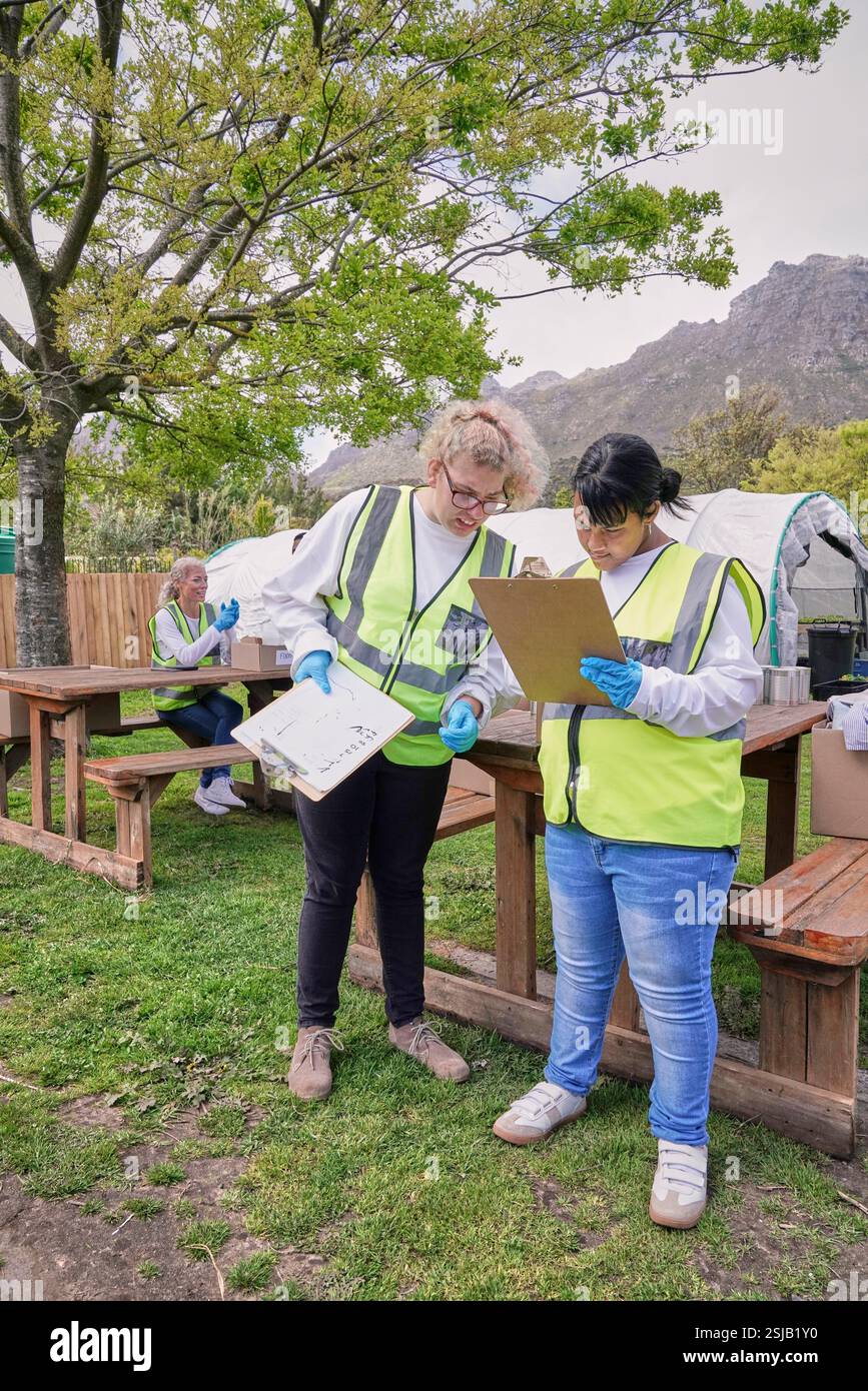 Two female volunteers checking list during packaging donation boxes Stock Photo